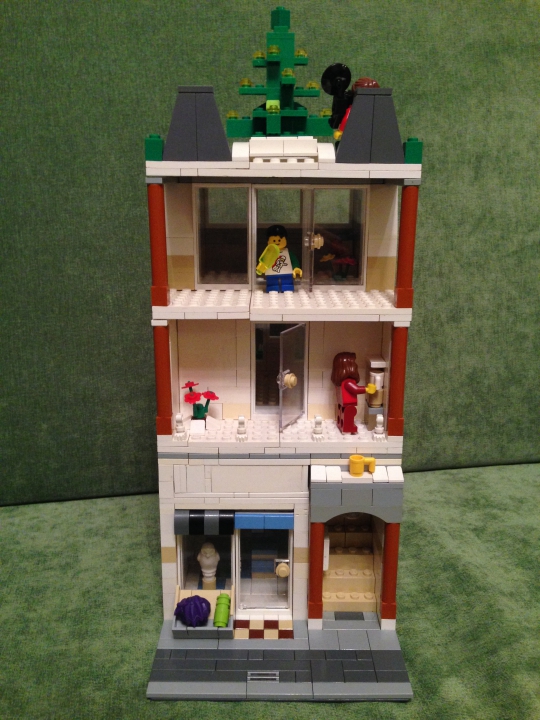 LEGO MOC - New Year's Brick 2014 - Прекрасный Новогодний Домик): Фасад дома достаточно красив.Всего в доме 3 этажа, на первом- магазин новогодних подарков,на втором-жилая квартира,на третьем-ремонт, а вот на крыше находится елка-главный атрибут Нового Года!