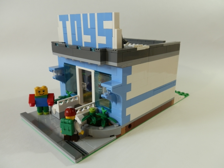 LEGO MOC - New Year's Brick 2014 - Магазин игрушек.: Магазин-то модульный. Наверняка стоит на какой-нибудь оживлённой улице между другими домами и магазинами. Перед входом стоит человек в костюме, эдакая живая реклама. И ребёнок, который засмотрелся на что-то в витрине магазина.