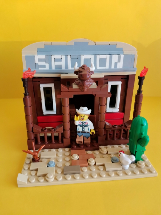 LEGO MOC - LEGO-contest 16x16: 'Western' - SALOON: У входа посетителя встречают горящие факелы, а также муляж головы животного. 