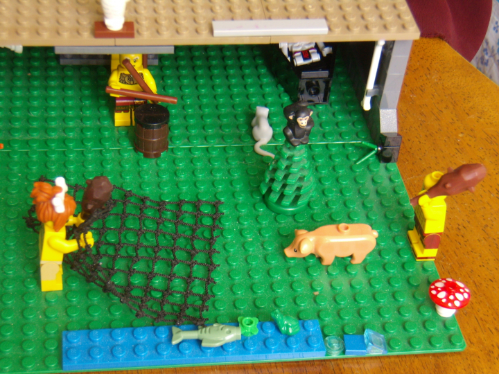 LEGO MOC - Because we can! - Caveman fire discovery: Река и улов на берегу. Пещерная женщина постаралась и поймала сетью к обеду рыбу, лягушку и водоросли, а теперь вот-вот поймает свинью.